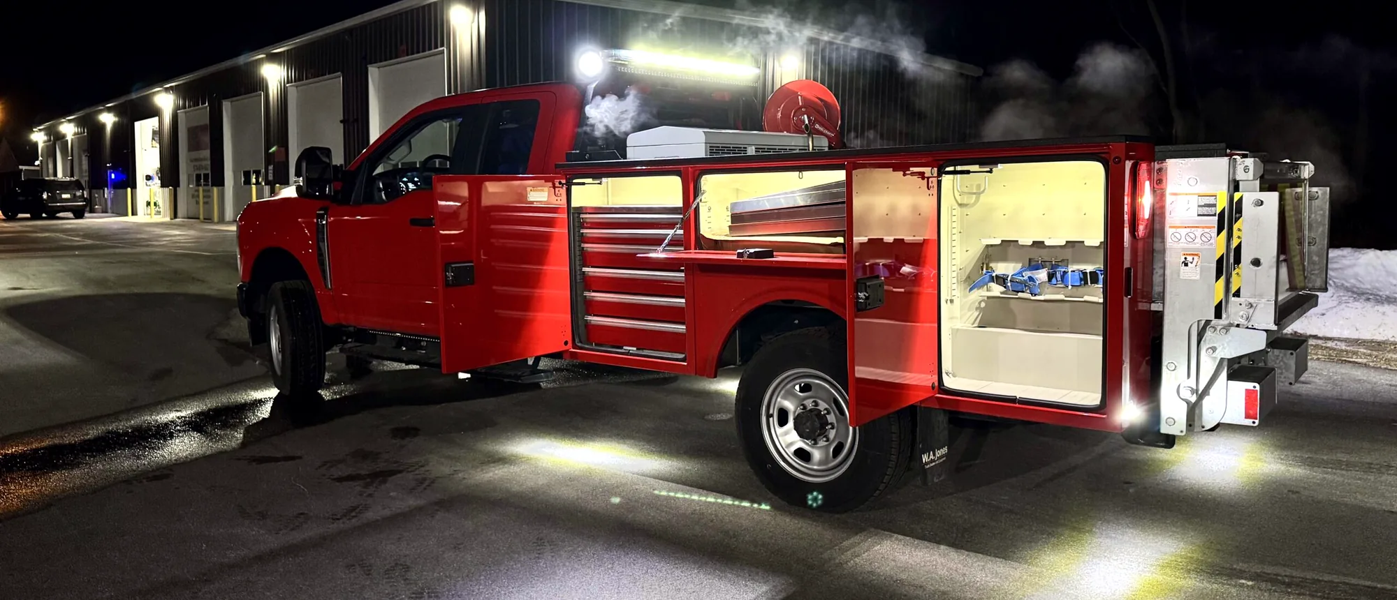Service truck with emergency lighting outside the shop at night